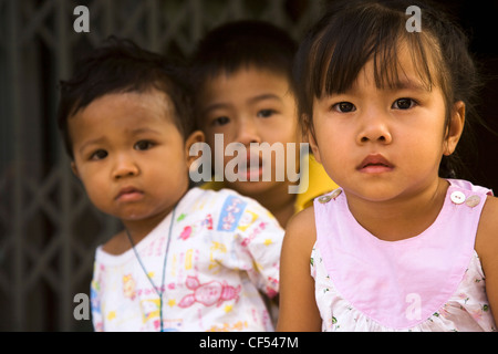 Les jeunes enfants en fin d'après-midi en face de l'entrée shophouse Thaïlande Bangkok Thaïlande Asie Asie enfant thaïlandais Banque D'Images