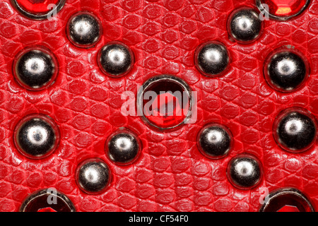 La texture en cuir rouge avec rivets et pierres Banque D'Images