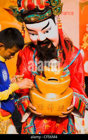 Thaïlande, Bangkok, Chinatown, membre d'une troupe de danse avec tête caractère papier mâché de collecter de l'argent au Nouvel An chinois. Banque D'Images