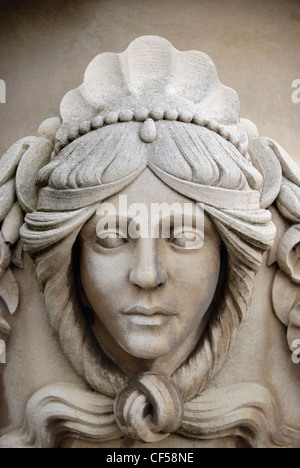 Une sculpture d'un visage de femme sur une urne en pierre dans les jardins italiens. Banque D'Images