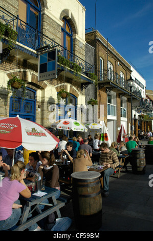 Les gens assis au soleil à l'extérieur de la Rutland Ale House pub à côté de la Tamise. Banque D'Images