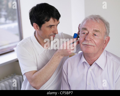 Allemagne, Hambourg, Doctor examining patient avec un otoscope Banque D'Images