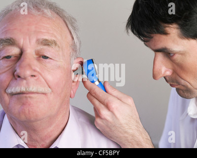 Allemagne, Hambourg, Doctor examining patient avec un otoscope Banque D'Images