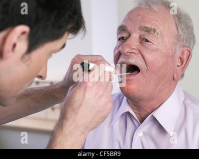 Allemagne, Hambourg, Doctor examining patient avec abaisse-langue Banque D'Images