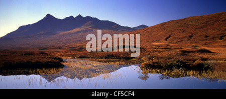 Vue panoramique sur collines avec petit Lochan en premier plan et les montagnes Cuillin en arrière-plan. Banque D'Images