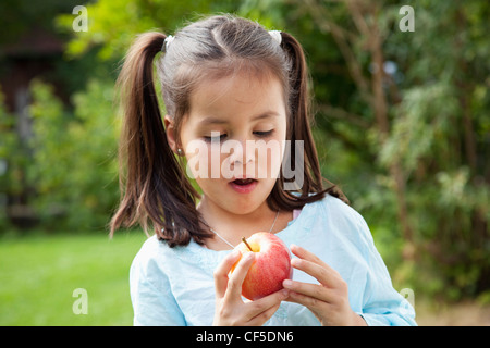 Allemagne, Bavière, Huglfing, girl looking at apple, Close up Banque D'Images