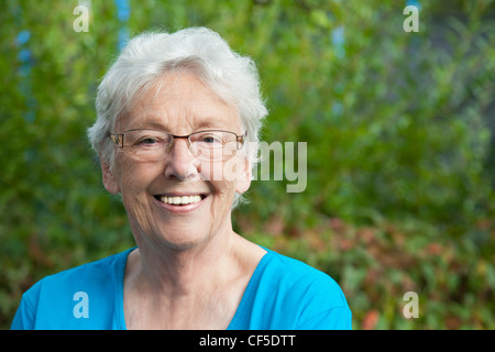 Allemagne, Bavière, Huglfing, Senior woman in garden, smiling, portrait Banque D'Images