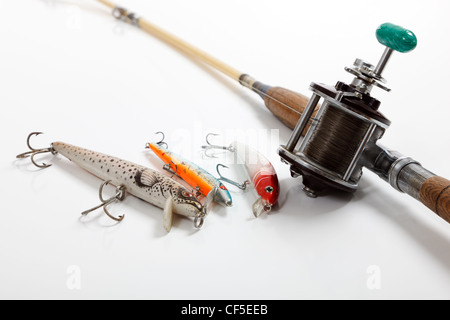 Un ensemble de fournitures de pêche sur un fond blanc avec des leurres et d'une canne et d'une canne à pêche et le moulinet Banque D'Images