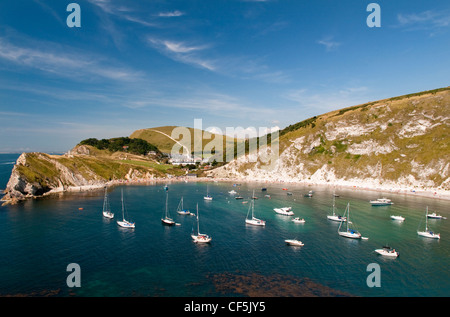 Bateaux amarrés dans la crique de Lulworth Cove, sur la Côte Jurassique, site du patrimoine mondial. Banque D'Images