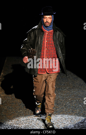 Vivienne Westwood Milan collection Prêt à Porter Automne Hiver Homme barbu portant veste en cuir noire sur vérifier gilet Banque D'Images