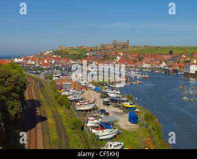 Les voies de chemin de fer longeant bateaux amarrés sur la rivière Esk à Whitby. Banque D'Images