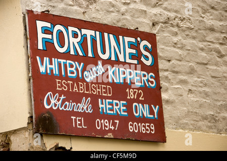 La Fortune en bois ancienne guérie Whitby signe à l'extérieur du magasin de poisson. Banque D'Images