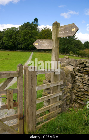 Sentier public en bois signe et muret de pierres sèches à proximité de Hawkshead. Banque D'Images