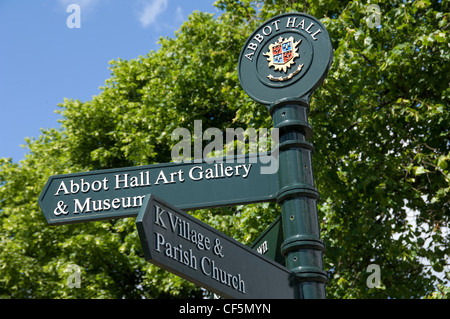 Un signe d'information touristique avec des directions d'Abbot Hall Art Gallery and Museum et Kendal Village et église paroissiale. Banque D'Images