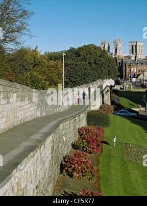 Une famille à marcher le long des murs de la ville en direction de York Minster. Banque D'Images