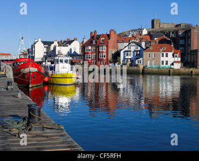 L'église de la Vierge Marie sur la falaise Est donnant sur les bateaux de pêche amarrés dans le port de Whitby. Banque D'Images