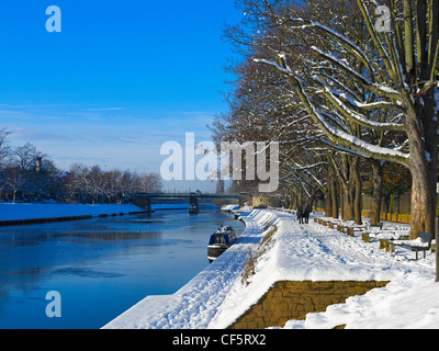 Un couple en train de marcher le long de chemin de randonnée dans la neige en direction du pont ferroviaire de Scarborough en hiver. Banque D'Images