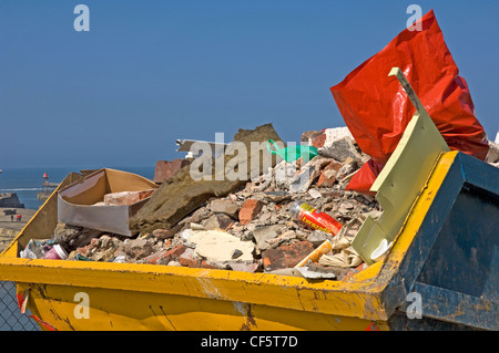 Un métal jaune skip to rempli de builders décombres. Banque D'Images