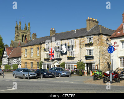 The Black Swan Hotel, une auberge historique maintenant un hôtel de caractère situé dans le marché. La tour de l'église All Saints est dans l'arrière-plan. Banque D'Images