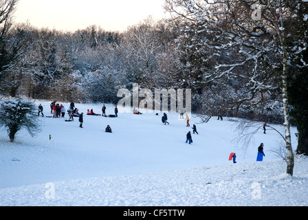 Les familles appréciant les pentes couvertes de neige d'Epsom Downs. Banque D'Images