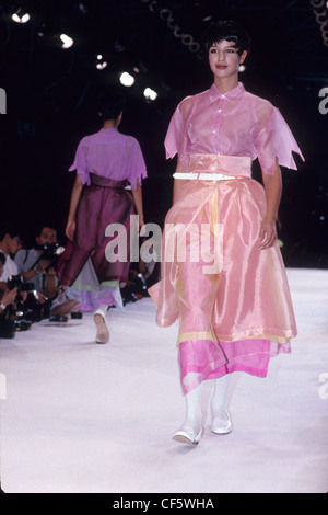 Commes de Garcons Printemps Été Mannequin portant robe de mousseline rose révélant avec jupe couleur pêche, avec pompes blanches Banque D'Images