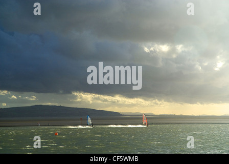 Planche à voile sur le lac marin à West Kirby sur la Péninsule de Wirral. Banque D'Images