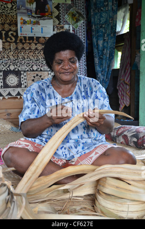 Le tissage de nattes traditionnelles femme fidjienne avec feuilles de pandanus. Banque D'Images