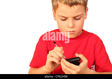 Smart petit garçon en chemise sport rouge écrit remarque dans téléphone Banque D'Images