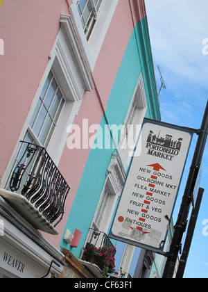 Le marché de Portobello signe sur un poste de Portobello Road à l'extérieur terrasse Victorienne peint de couleurs vives, propriétés. Banque D'Images