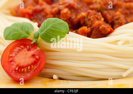 Des pâtes avec sauce tomate et basilic frais Banque D'Images