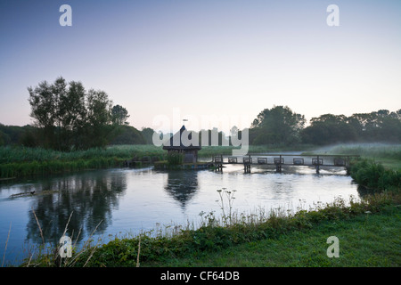 Cabane de pêche de chaume et les pièges de l'anguille sur la rivière Test à Longstock. Banque D'Images