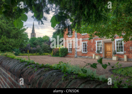 Vue de la façade avant de Sutton Bonington Hall, une maison de campagne de la Reine Anne, avec le clocher de l'église St-Michel de la b Banque D'Images