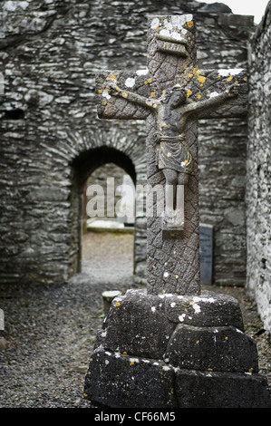 Un crucifix en pierre dans les ruines historiques de Monasterboice fondé à la fin du 5ème siècle par Saint Buite. Banque D'Images