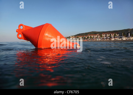 Bouée d'ancrage orange flotte sur la mer. plage pourrait être vu dans la distance Banque D'Images