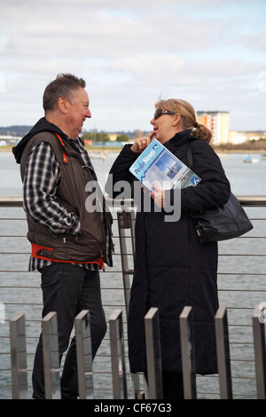 D'âge mûr jouissant chacun d'autres société lors de l'ouverture du nouveau pont de levage double voiles dans le port de Poole Poole, Dorset sur Feb 2012 Banque D'Images