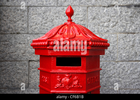 Un gros plan d'une rouge traditionnel post box à côté d'un mur dans le Tower Bridge. Banque D'Images