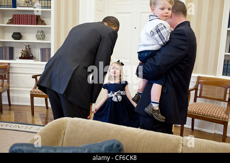 Le président américain Barack Obama salue la fille d'un United States Secret Service Agent avant le départ une photo dans le bureau ovale 1 Mars, 2011 à Washington, DC. Banque D'Images