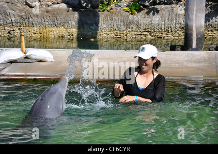 UNEXSO Dolphin Close Encounter, Bahamas - dolphin éclaboussures et crache de l'eau sur la femme comme une blague Banque D'Images