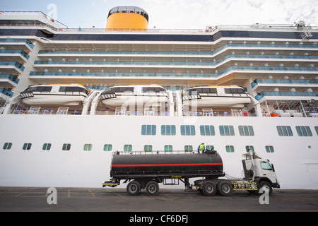 Camion-citerne à gaz restant dans Qaboos Port. Bateau de croisière derrière camion. l'homme sur le dessus du chariot. Banque D'Images