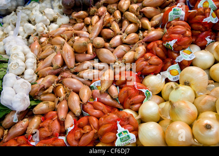 Les oignons et l'ail en vente sur un étal au marché de l'arrondissement. Banque D'Images