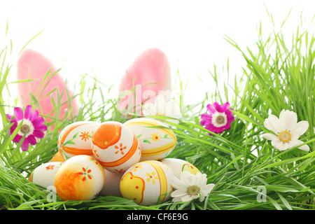 Les Œufs de pâques avec Daisy fleur sur l'herbe verte fraîche Banque D'Images