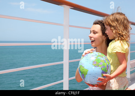 Mother and Daughter holding inflatable globe sur un paquebot de croisière, moitié du corps de pont Banque D'Images