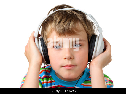 Petit garçon en chemise rayée et casque en main sur place et regarde Banque D'Images