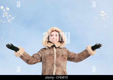 Jeune fille dans la neige vers le haut du capot mains jette Banque D'Images