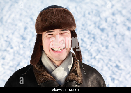 Les jeunes peuplements en hiver sur la neige à ear-flaps hat et rit Banque D'Images