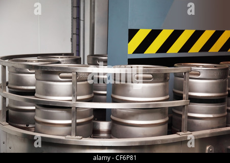 Plusieurs barils de bière en aluminium se déplacer sur le convoyeur. mur bleu est situé derrière le convoyeur Banque D'Images