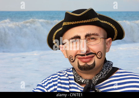 Portrait of smiling man with drawed barbe et moustache en costume pirate. mer vague en dehors de la vue. Banque D'Images