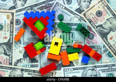 Des briques Lego, Lego house en briques et des modules ou des ruines reposant sur American dollar bills Banque D'Images