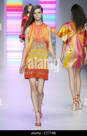 Pucci Milan Prêt à Porter Printemps Été Brunette model long cheveux portant une robe jaune et orange cut out detail Banque D'Images