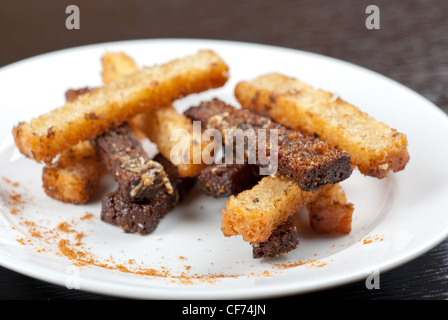 Rusk avec de l'ail sur une plaque à fond de bois Banque D'Images